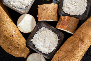 pile of cassava and cassava flour on dark background (Manihot esculenta)
