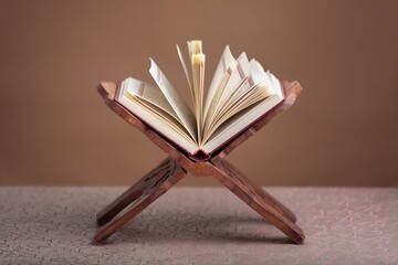 Quran Book with on a stand on brown background