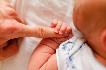 A A Father's Love. Heartwarming Moment of Connection. A Father's Gentle Touch as His Finger Holds the Tiny Hand of His Precious Newborn Child