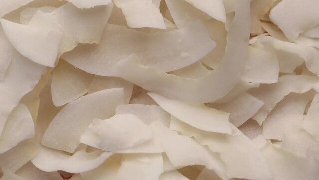 dried coconut slice close-up, rotation in circle. dried coconut Turning. selective focus.  