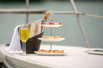 Rich man sleep lying in yacht ship for eat Afternoon tea and champagne . yachting man relax with cake stand decorate catering banquet services with champagne in sea and sunlight
