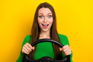 Portrait of positive overjoyed person arms hold wheel open mouth isolated on yellow color background