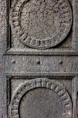 ancient gates with round carved elements, old paint texture restoration and restoration of residential building or an art object. wooden door with peeling paint, craquelure. wooden structures