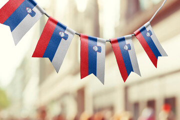 A garland of Slovenia national flags on an abstract blurred background