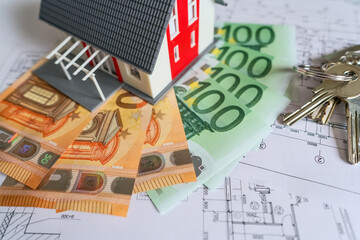 Private house model and euro banknotes, house construction costs