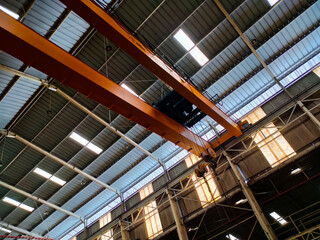 Yellow overhead crane installed on the manufacturing industry plant shop. Jib crab trolley with...