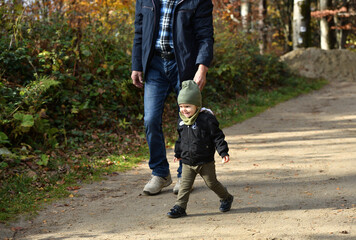 2-year-old girl learns to walk on her own during a forest hike on a park trail