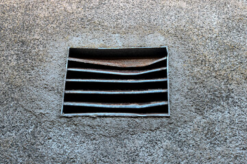 Old Damaged Metal Air Vent in an Old Roughcast Wall