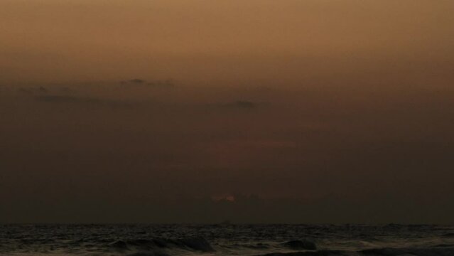 Bright sunset with a big red sun under the surface of the Indian Ocean. Inspiration, idyll, tourism, travel