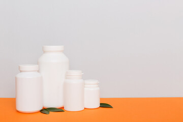 supplement pills with medicine bottle health care and medical top view. Vitamin tablets. Top view mockup bottle for pills and vitamins with green leaves, natural organic bio supplement, copy space