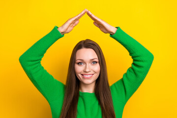Obraz na płótnie Canvas Portrait of lovely positive girl arms demonstrate roof above head gesture isolated on yellow color background