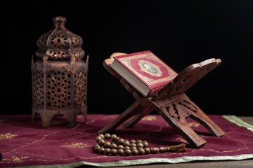Holy Book of Muslims with breads on dark background