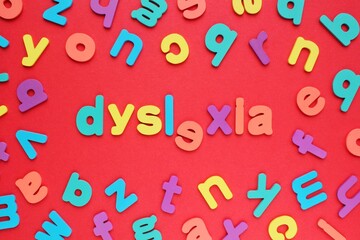 Color alphabet letters on red background. World Dyslexia Day concept. Solving the educational...