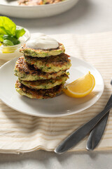 Zucchini fritters or vegetarian zucchini pancakes served with yogurt sauce