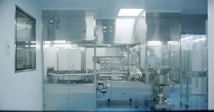 Factory Cleanroom. Pharmaceutical, Biotechnological and Semiconductor Creating Manufacturing Process. Sterile Pharmaceutical Manufacturing Laboratory where Scientists in Protective Coveralls.