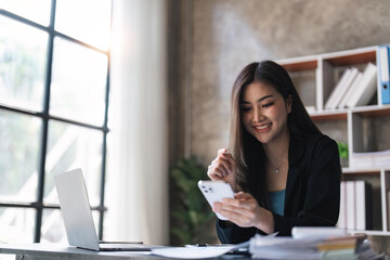 Obraz premium Businesswoman using mobile phone at work, chatting or social network concept
