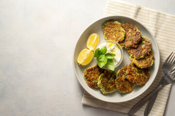 Zucchini fritters or vegetarian zucchini pancakes served with yogurt sauce