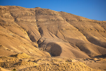  Z Madaby nad Morze Martwe w Jordanii. Krajobraz pustynnych gór z pięknym, bezchmurnym niebem.  - obrazy, fototapety, plakaty