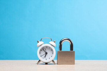 Metal padlock with alarm clock on a blue background
