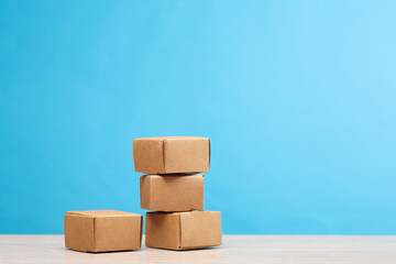 Stack craft cardboard boxes on a blue background. Delivery, shopping, post, transportation, warehousing