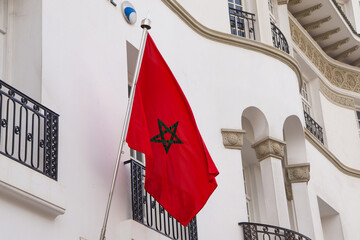 Waving Moroccan Flag on its Pole Hung in Front of Building 
