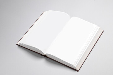 Open blank book with white pages on a gray background. Template for design, mock up