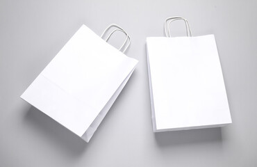 Two paper white shopping bags on gray background. Template for design