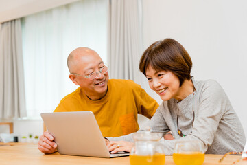 パソコンを楽しそうに操作する50代から60代の夫婦2名