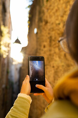 Portraits of a tourist taking photos with her mobile.