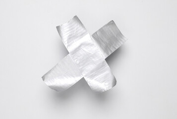 Cross stripes metallic adhesive tape on white background. Top view