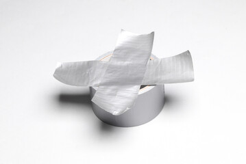 Roll of metallic duct tape with cross tape on white background. Top view