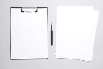 Clipboard with blank papers and pen on gray background. Business concept. Template for design