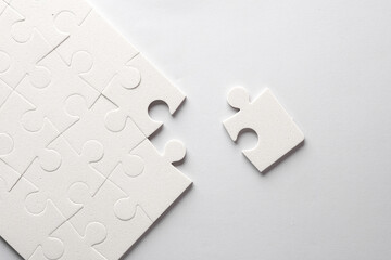 Obraz premium White jigsaw puzzle pieces on a gray background.