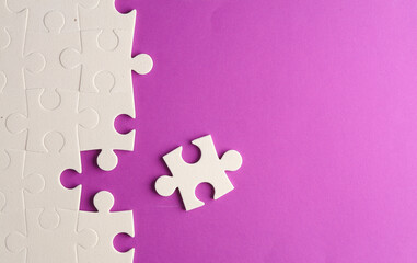 White jigsaw puzzle pieces on purple background.