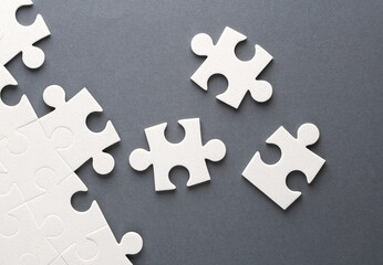 White jigsaw puzzle pieces on dark background.