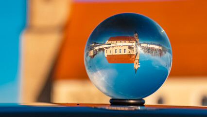 Crystal ball landscape shot with a church and reflections on a car roof at Kurzenisarhofen, Bavaria, Germany