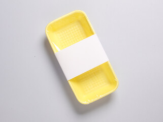 Plastic grocery container for product packaging with a white label in a supermarket on a gray background