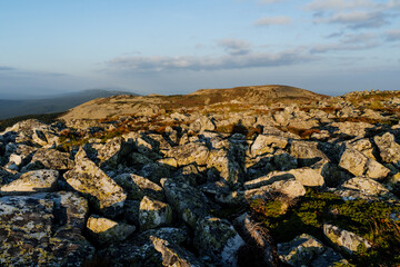 The shadow of a man against the background of stones, a mountain trip alone, a tourist meets the dawn on the mountain, large stones, a flat top.