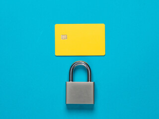 Secure your finances. Yellow blank bank card with padlock on blue background