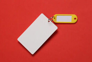 Plastic key card with tag on red background. Template for design