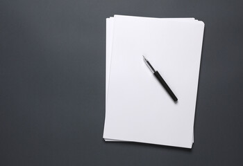 Sack of white a4 paper with a pen on a dark background. Business concept