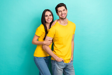 Photo of pretty sweet husband wife dressed yellow t-shirts embracing smiling empty space isolated turquoise color background