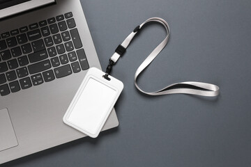 Laptop and id card on belt, dark background. Template for design. Top view