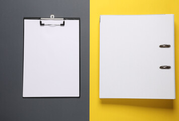 White binder folder and clipboard on a yellow gray background. Business concept. Top view