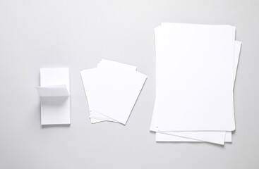White empty sheets of paper of different shapes and sizes on gray background