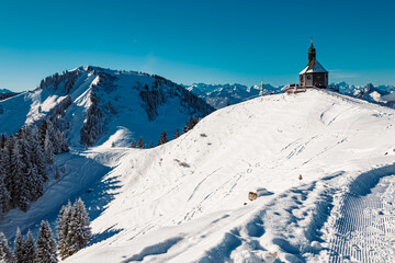 Fototapeta na wymiar Alpine winter view with a chapel at Mount Wallberg, Rottach-Egern, Lake Tegernsee, Bavaria, Germany