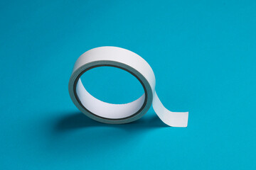Roll of white duct tape on blue background. Creative mockup