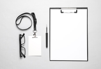 Clipboard with a blank sheet of paper, id card on gray background. Business concept. Template for design. Top view. Flat lay