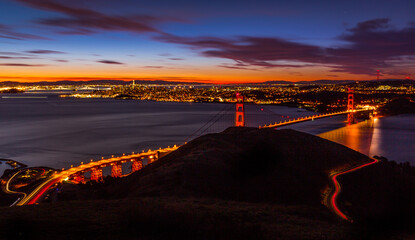 Sunrise over Golden Gate bridge with San Francisco skyline in the background	