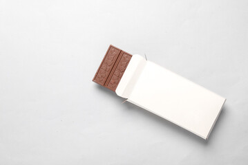 Mockup of white cardboard box with chocolate bar on gray background